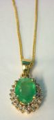 An Emerald and diamond cluster pendant on fine chain