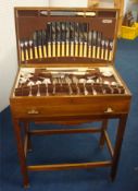 A Canteen of silver plated cutlery in a walnut cabinet of Deco design