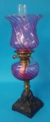 A cranberry glass oil lamp with cranberry glass shade, 60cm tall