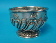 A silver sugar bowl richly embossed with decoration on feet, 11.50cm diameter, 174.6g