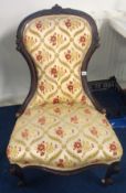 A Victorian spoon back nursing chair on china castors