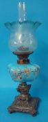A Victorian oil lamp with blue enamelled glass reservoir, cast iron base and blue shade, 59cm tall