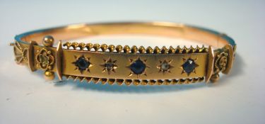 An antique 9ct gold bangle set with small sapphire and diamond stones, approximately 7.5g