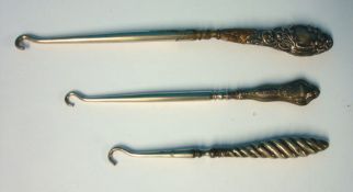 Three silver button hooks, tortoiseshell manicure set and a collection of various badges