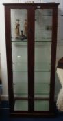 An early 20h century two door glass display cabinet with glass panels on all sides and adjustable