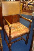 An oak and leather back carved elbow chair t/w An oak two door wardrobe, 129cm wide, with key