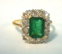 An emerald and diamond cluster ring set in 18ct yellow gold