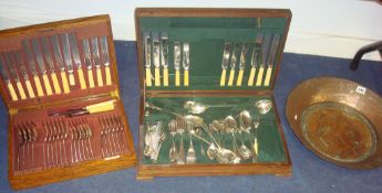 Collection of silver plated cutlery in two canteen boxes and a large heavy copper bowl
