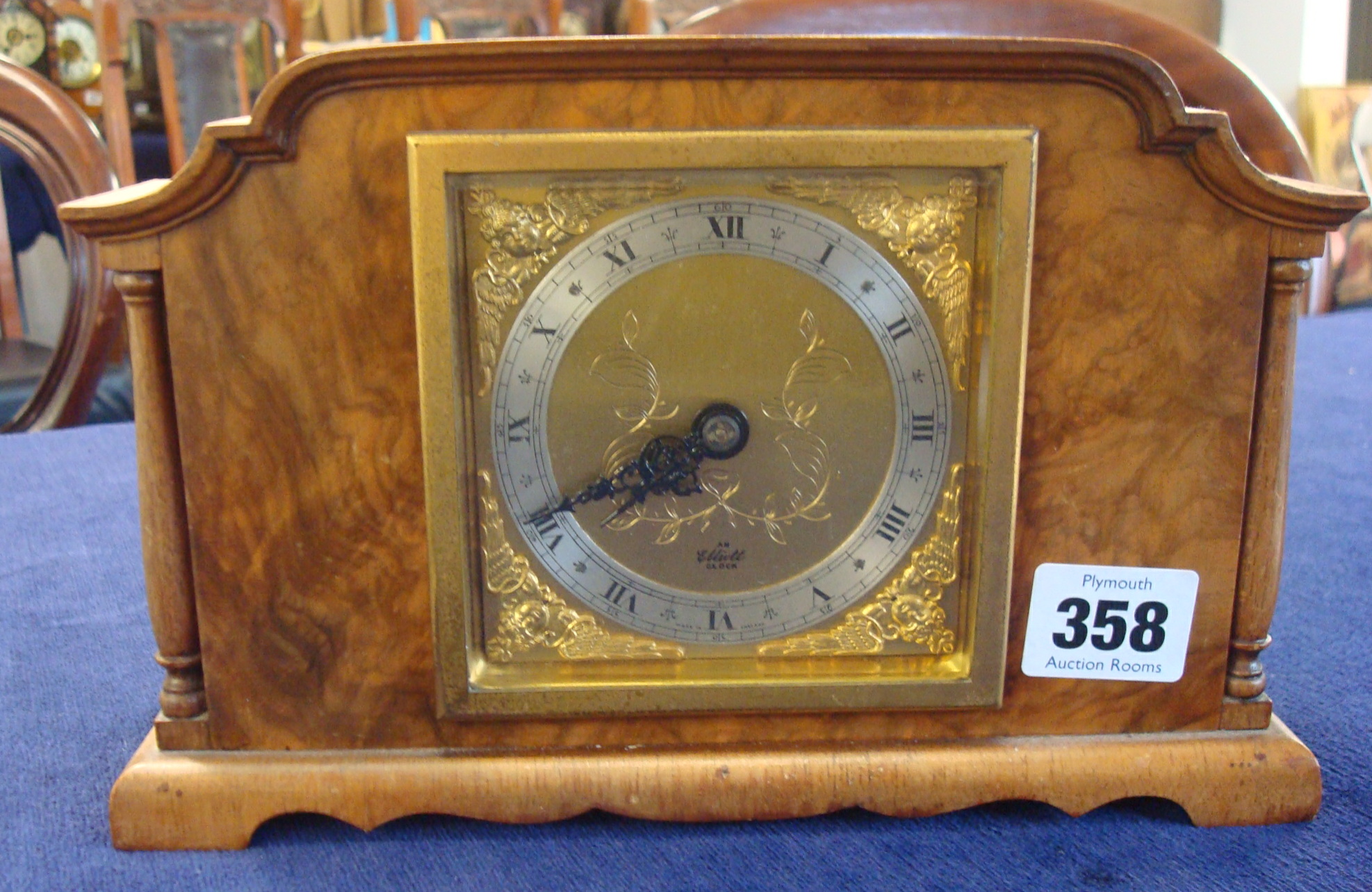 An Elliott walnut cased mantle clock with square brass dial