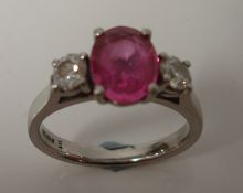 A sapphire and diamond three stone modern ring set with pink oval cut sapphire, approx 1.33ct, and a