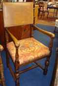 An oak and leather back carved elbow chair