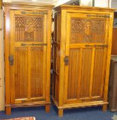 Pair of golden oak hall wardrobes of Gothic design with tracery and heraldic crests, 96cm wide x