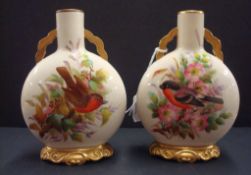 Pair of Royal Worcester small moon flask vases, each decorated with exotic birds and gilt work, 14cm