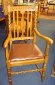 A 1920`s oak and barley twist elbow chair with drop in seat