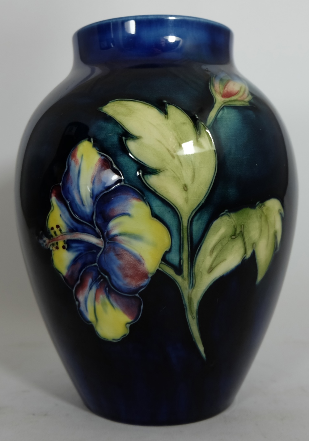 Moorcroft vase decorated in the hibiscus design, signed Walter Moorcroft, height 19cm