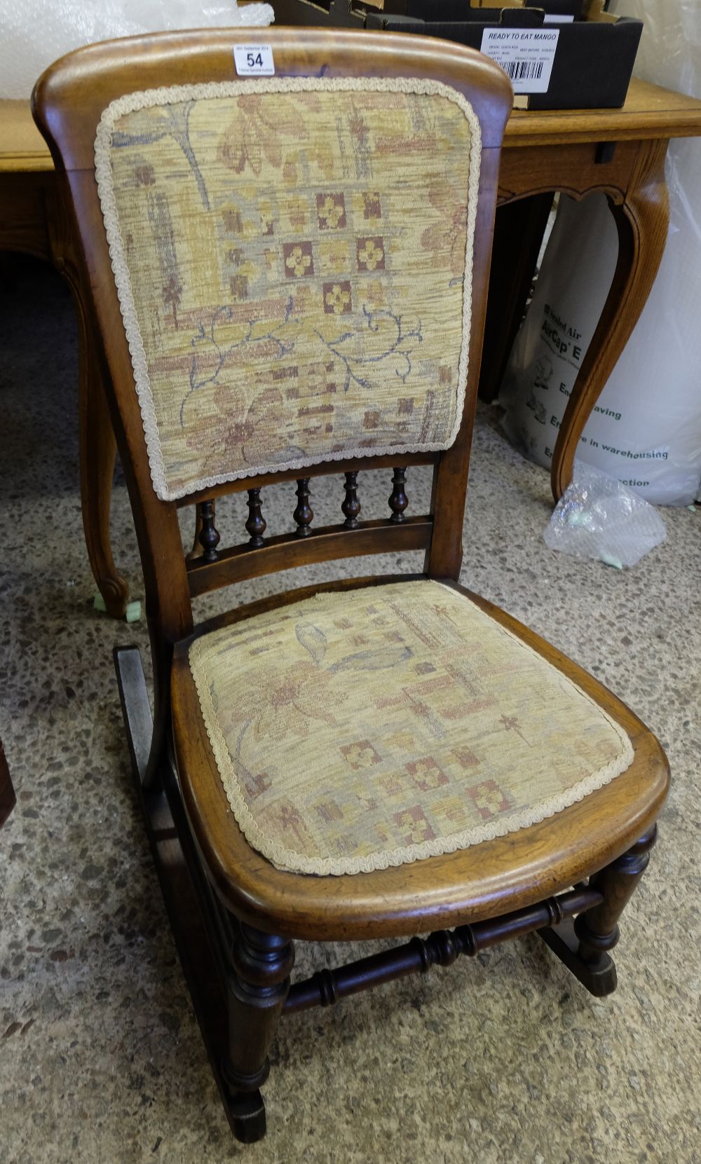 An Edwardian walnut upholstered rocking chair