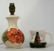 Moorcroft Lamp base decorated in the Hibiscus design and a Moorcroft shop mug decorated with a
