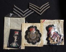 A collection of cloth badges and stripes to include Army Ordnance & Service Corps etc (5)