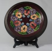 Moorcroft wall plaque decorated with Flowers in original wood frame dated 1993, diameter 30cm