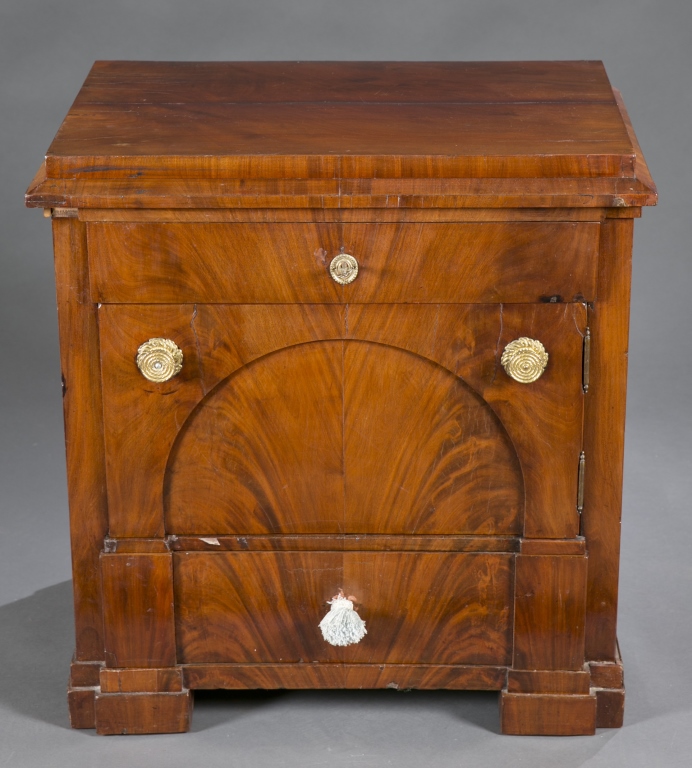 A neoclassical walnut  pot cupboard. 19th century. Having solid wood covered with book matched