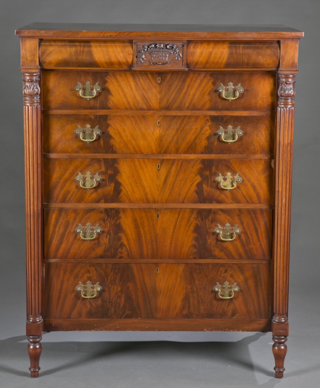 An Empire style chest of drawers. 19th c. Having dovetail construction, flame mahogany veneer,