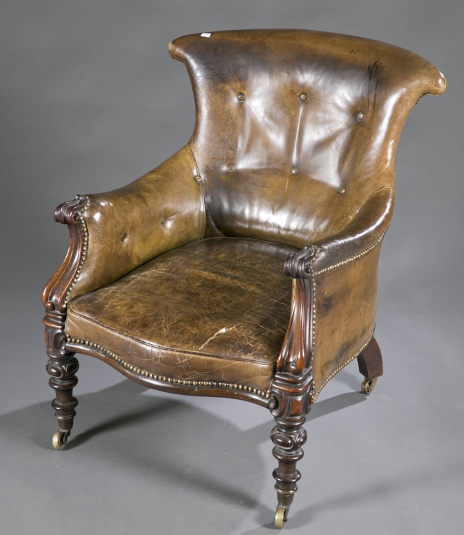 A green leather armchair. 19th c. Incorporating renaissance and rococo revival styles, brass