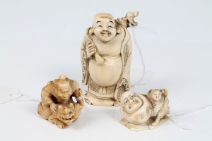 Three late 19th century Japanese carved ivory okimono of a warrior on a demon's back, boy with large