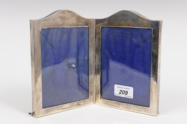 Edwardian silver folding double photograph frame of rectangular form, with shaped top (London 1907),