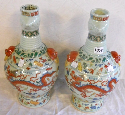 A pair of 15” bulbous bottle vases with flanking dog mask handles and polychrome air dragon