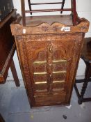 A CARVED HARDWOOD TWO DOOR CABINET