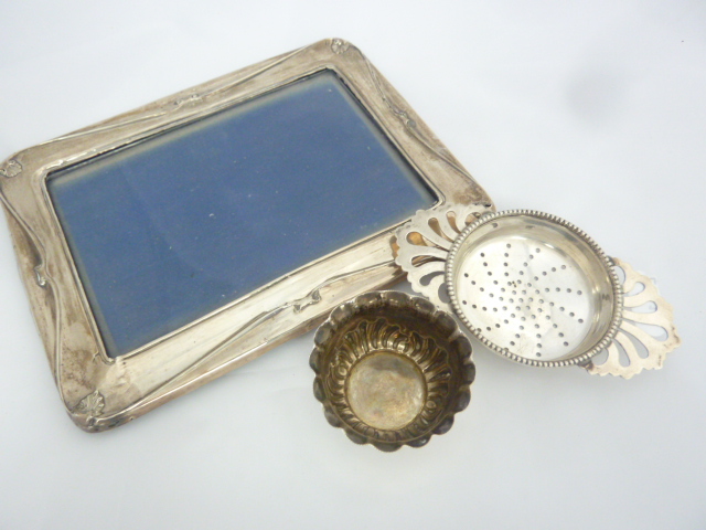 A SILVER PHOTOGRAPH FRAME, Birmingham 1913, a silver tea strainer and a silver salt (3)