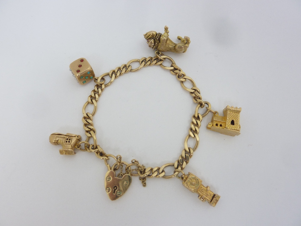 A 9CT GOLD CHARM BRACELET, comprising of five 9ct gold charms to the curb link chain and heart shape
