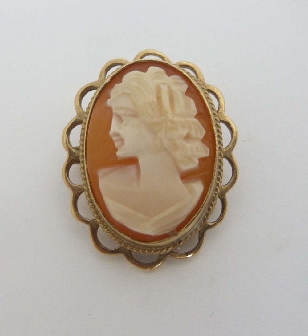 A CAMEO BROOCH, with a lady in profile with scalloped edge surround, can also be worn as a pendant