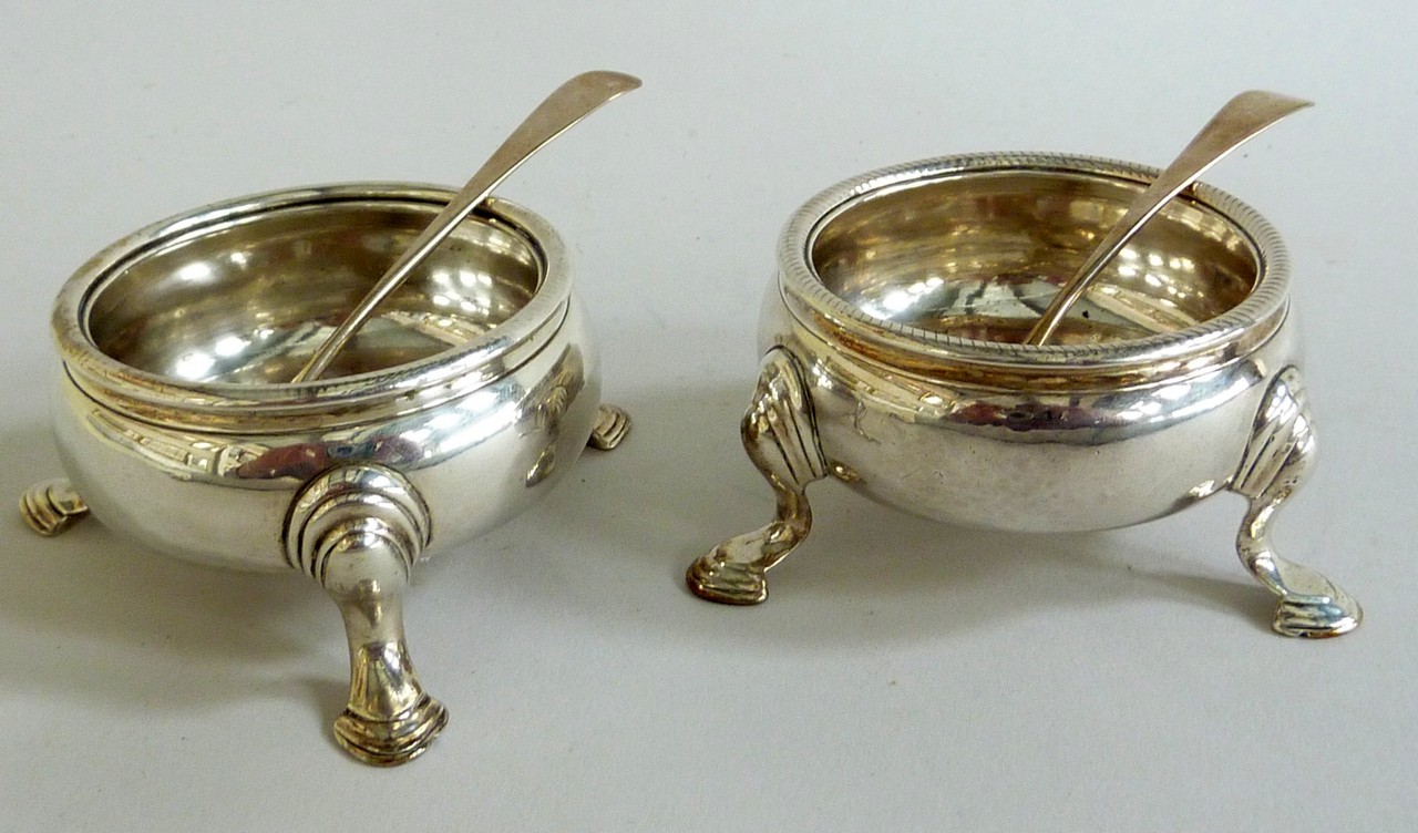 A NEAR PAIR OF SILVER CIRCULAR SALTS, hoof feet, London marks rubbed, and two Old English pattern