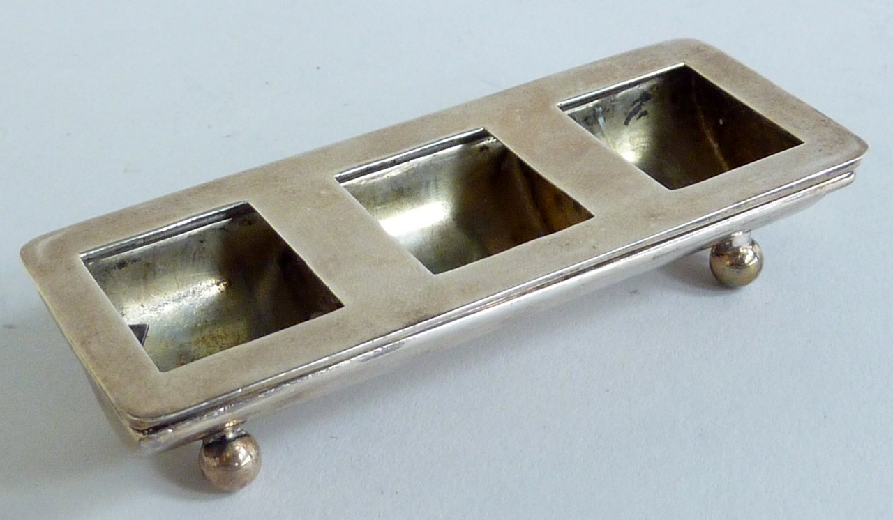 A SILVER TRIPLE STAMP DISPENSER, spring loaded hinged cover, (lacking glazing), gilt interior,