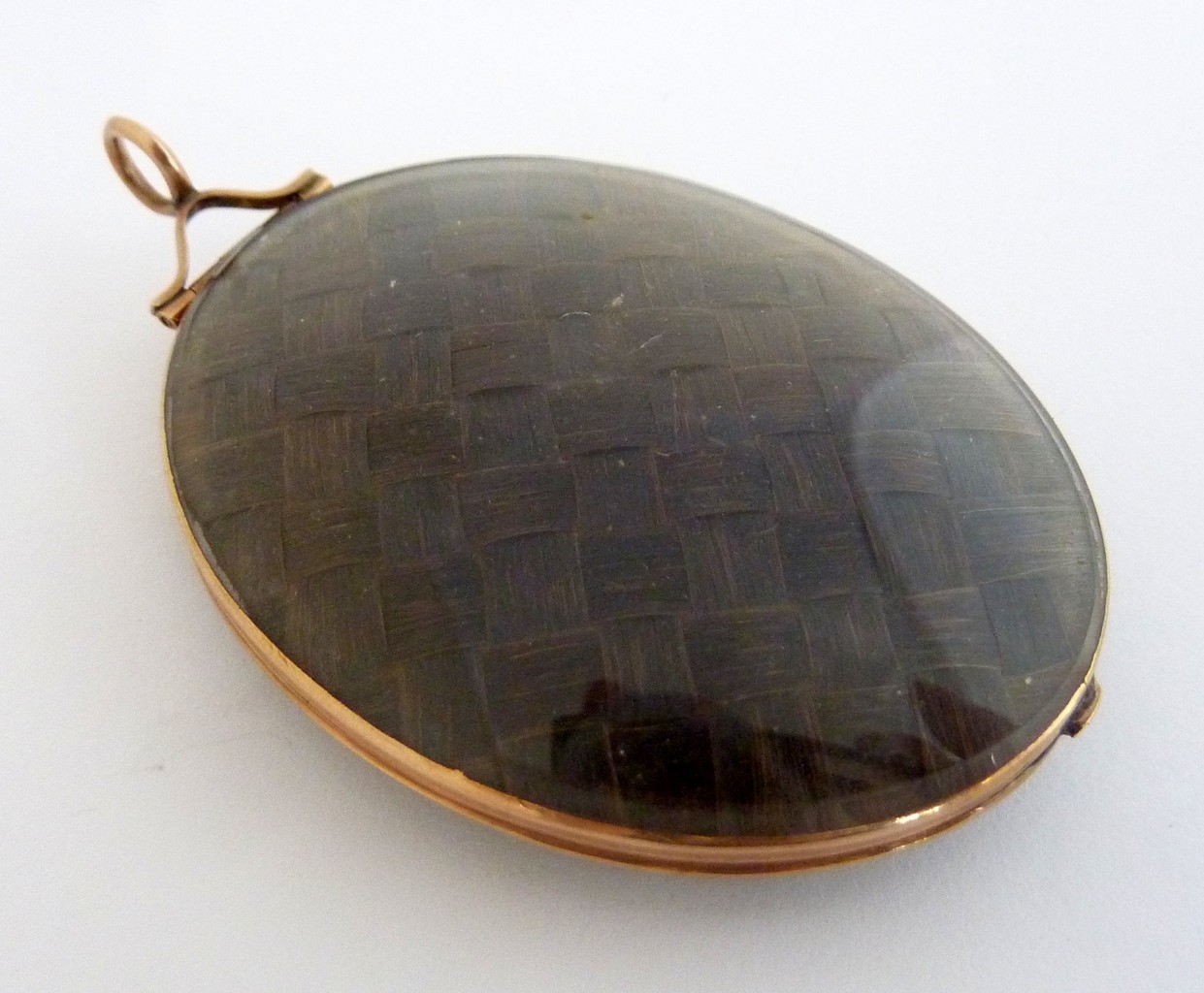 A LARGE OVAL MOURNING LOCKET, 19th century, with inter-woven brunette hair to each side of the - Image 2 of 2
