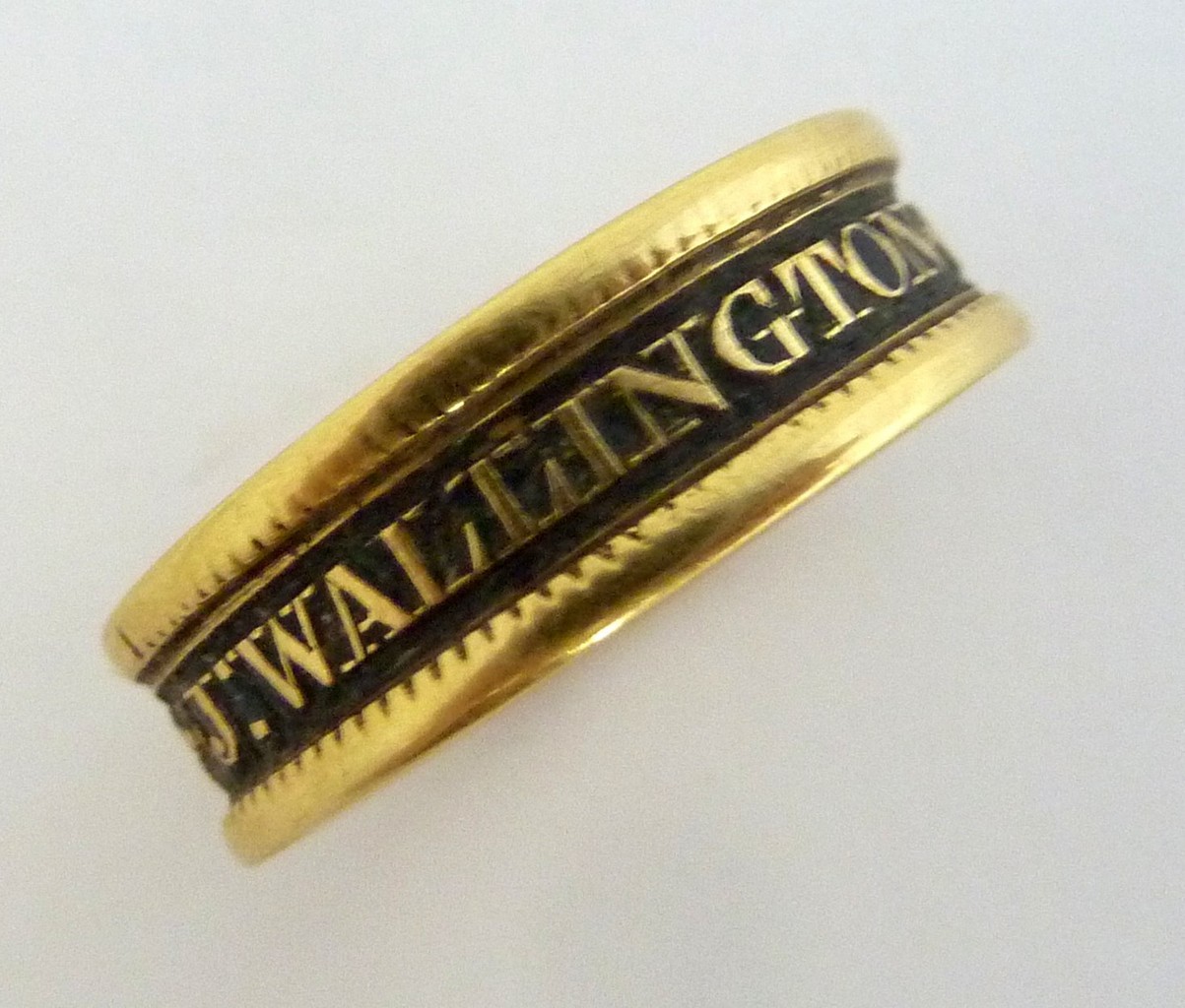 AN EARLY VICTORIAN 18CT YELLOW GOLD MOURNING RING, c.1823, the central black enamel band reading ‘J.