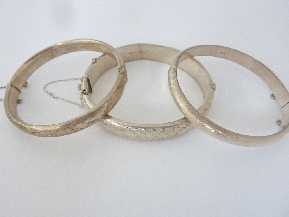 THREE ENGRAVED HINGED PATTERNED BANGLE, weight 43gms