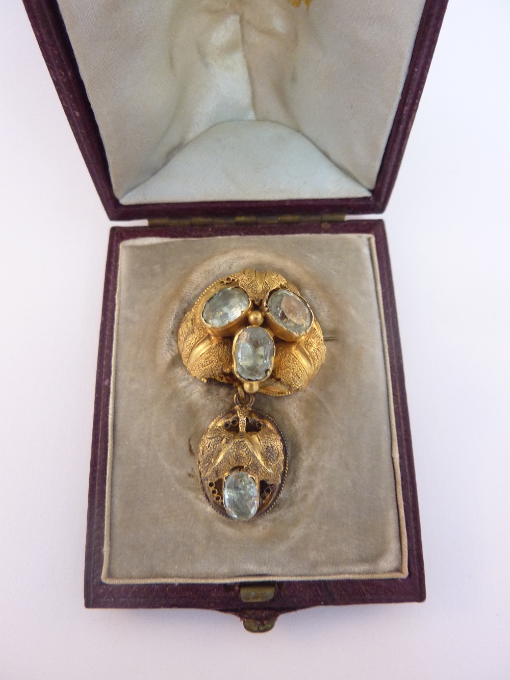 AN EARLY 20TH CENTURY BROOCH, designed as three oval shape aquamarines surrounded by blooming
