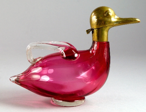 An Austrian cranberry glass and brass decanter, 20th century, in the form of a duck, 20cm wide