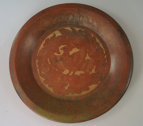 A European terracotta dish, 20th century, decorated with bird amidst foliage, 50cm diameter