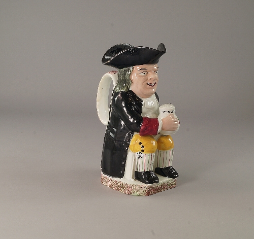 A Devenport Toby jug, 19th century, seated with foaming mug on his left knee, attired in black