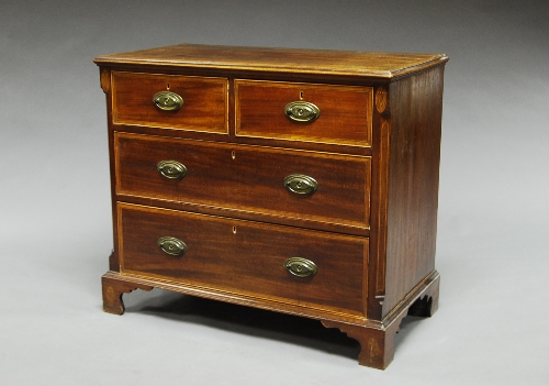 A late Georgian mahogany and fruit wood crossbanded chest, of two short and three long drawers,