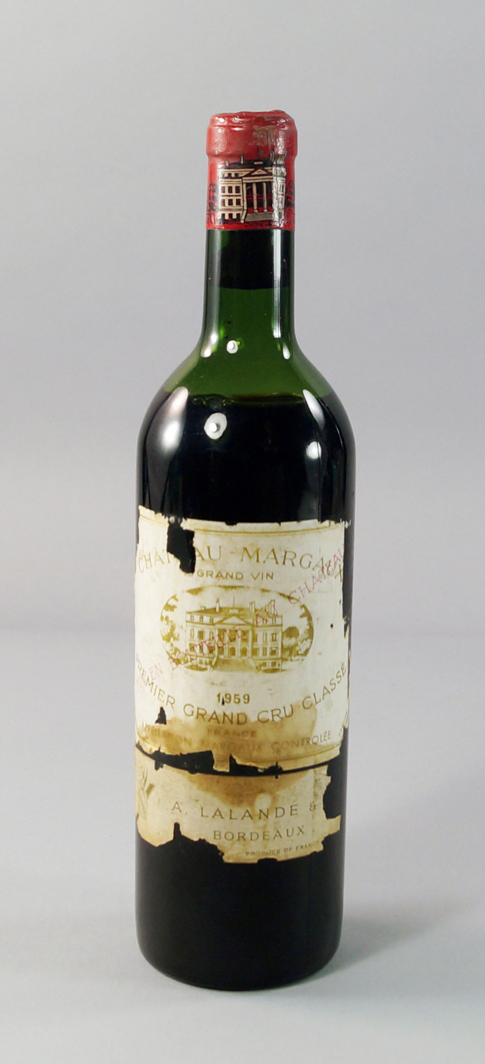 A bottle of Chateau Margaux Premier Grand Cru 1959, labels in poor condition, ullage to mid-