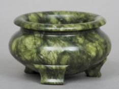 A Chinese spinach green jade censor
Of squat bulbous form, standing on three feet.  11 cms diameter.