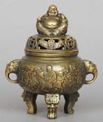 A small Chinese bronze censor
The pierced cover surmounted with the figure of Buddha, the main