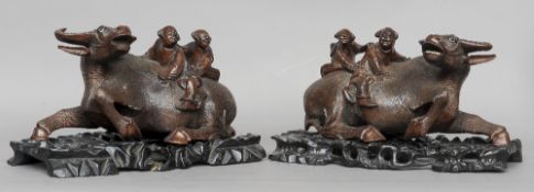 A pair of late 19th century Chinese carved hardwood models of water buffalo 
Each with two