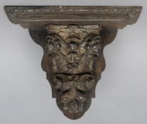 An 17th century and later carved oak bracket
The stepped top above the support carved with cherub
