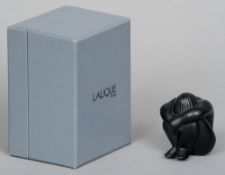 A boxed Lalique black glass model of a figure
With head between crossed arms.  6 cms high.