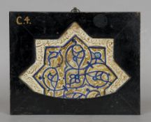 A 13th/14th century Islamic pottery plaque
Of arched star form centrally decorated with blue and